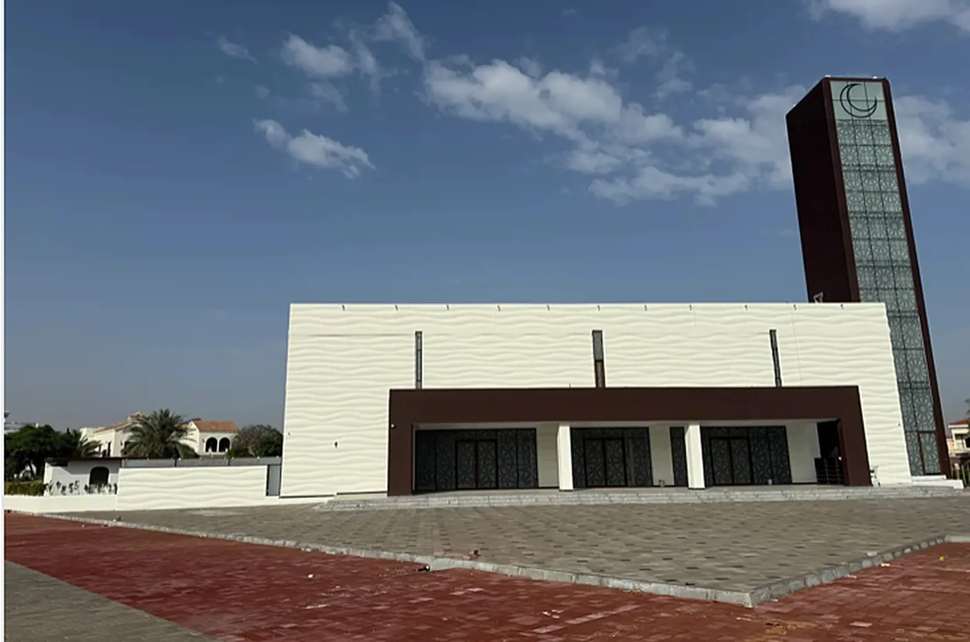 Completed masjid with minaret under a blue sky
